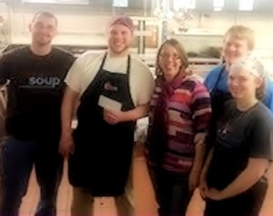 Jennifer Groce gves the Feed em Soup community organization a check for $100