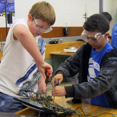 Photo of two boys disassembling something electronic