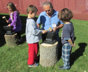 Glidden Homestead blacksmith Lucio Bortolin shows children how blacksmiths work with metal and then allows them to give it a try with kid -friendly tools.