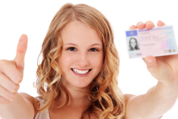 A girl shows off her driver's license after completing one of the graduated driver licensing programs.