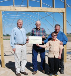 The DeKalb County Farm Bureau Foundation for Agriculture recently presented a check to the Walnut Grove Vocational Farm to assist with agricultural based training for people with special needs. Shown in front of one of the greenhouses under construction are: (from left) Dan Kenney, DeKalb County Community Gardens Executive Director; Allan Aves, Farm Bureau Foundation Director; Scott and Gene Heinsohn, with Walnut Grove Vocational Farm