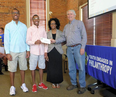 Members of Youth Engaged in Philanthropy (YEP) present a grant check to Dan Kenney, Director of DeKalb County Community Gardens. YEP is one of many grant making programs offered by the DeKalb County Community Foundation.